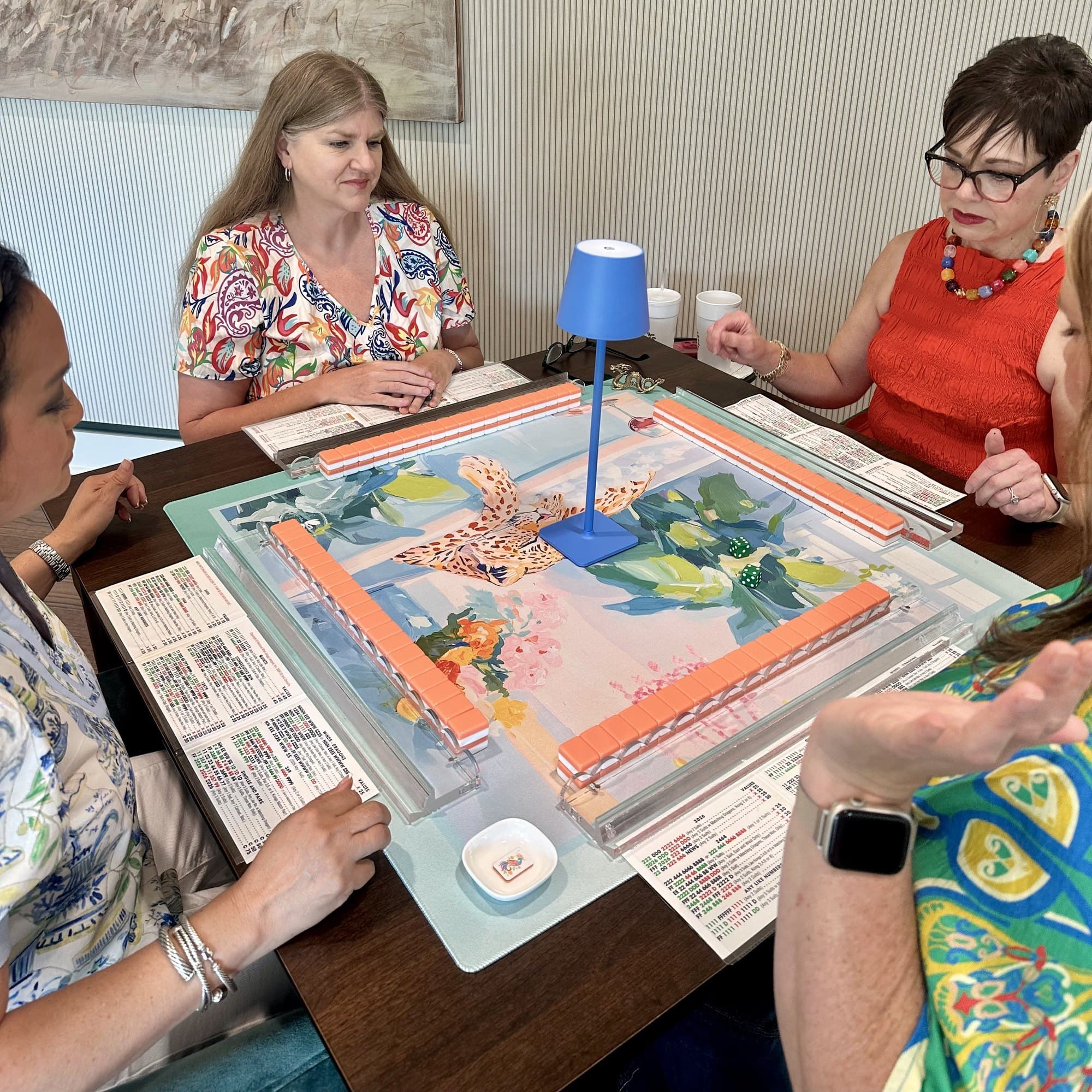 Friends playing mahjong together around a table